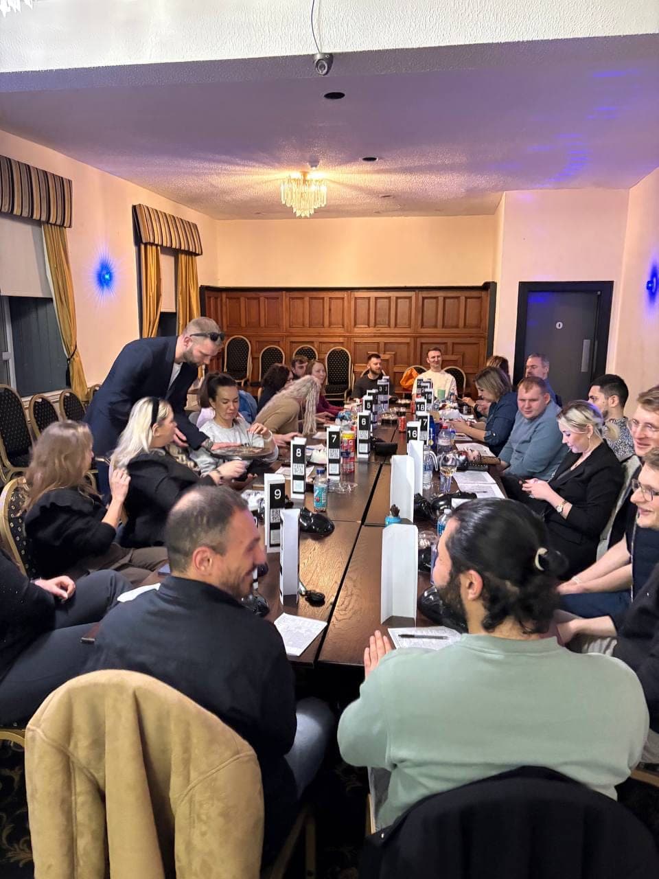 A packed table of colleagues mid-game at a corporate Mafia Kilty session